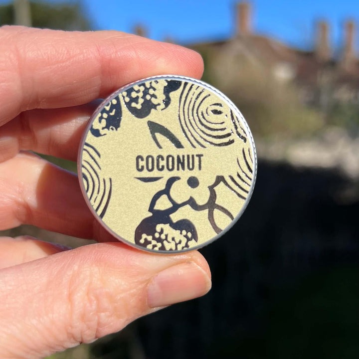 Hand holding coconut lip balm tin