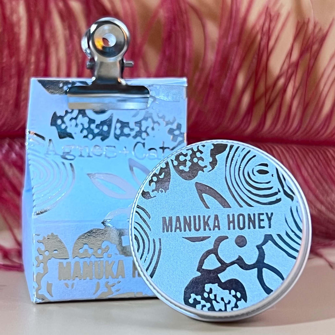 Manuka Honey lip balm tin shown outside of outer packaging