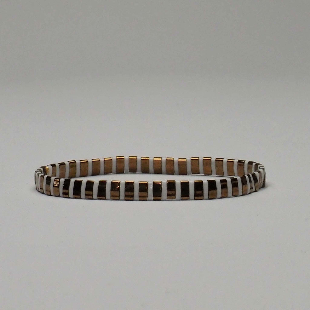 Gold and white Miyuki Glass Bead bracelet, taken against a plain background