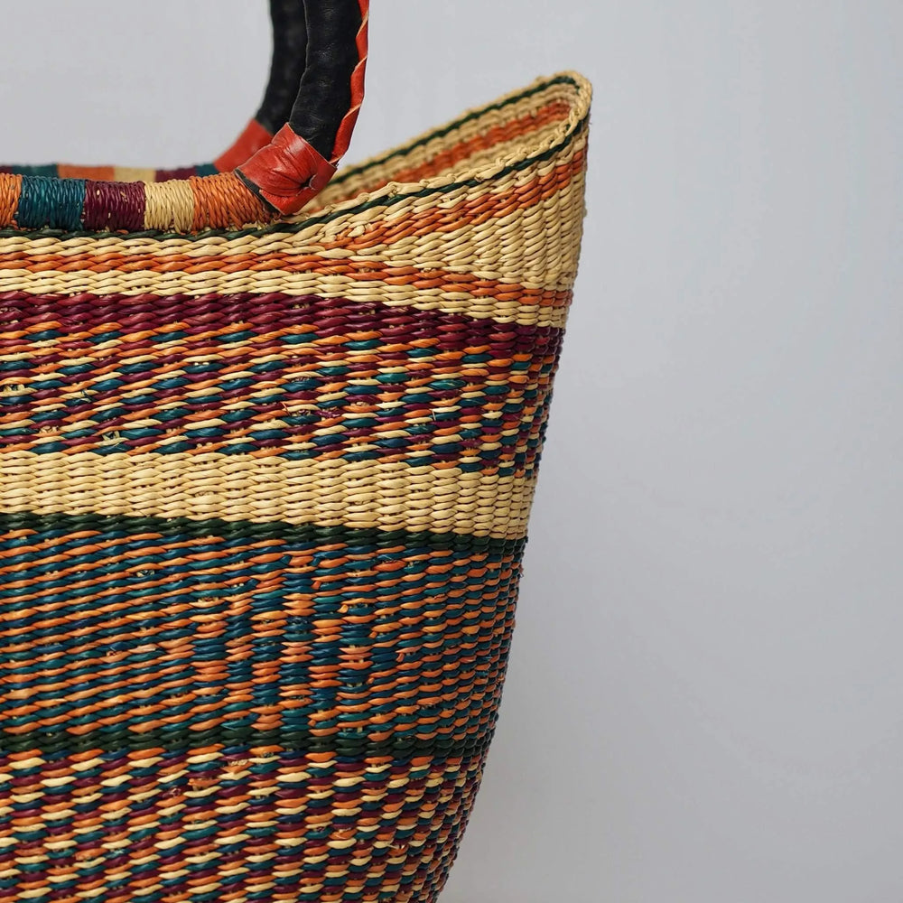 Close up of shopper Basket in earthy tones and intricate pattern with leather handles