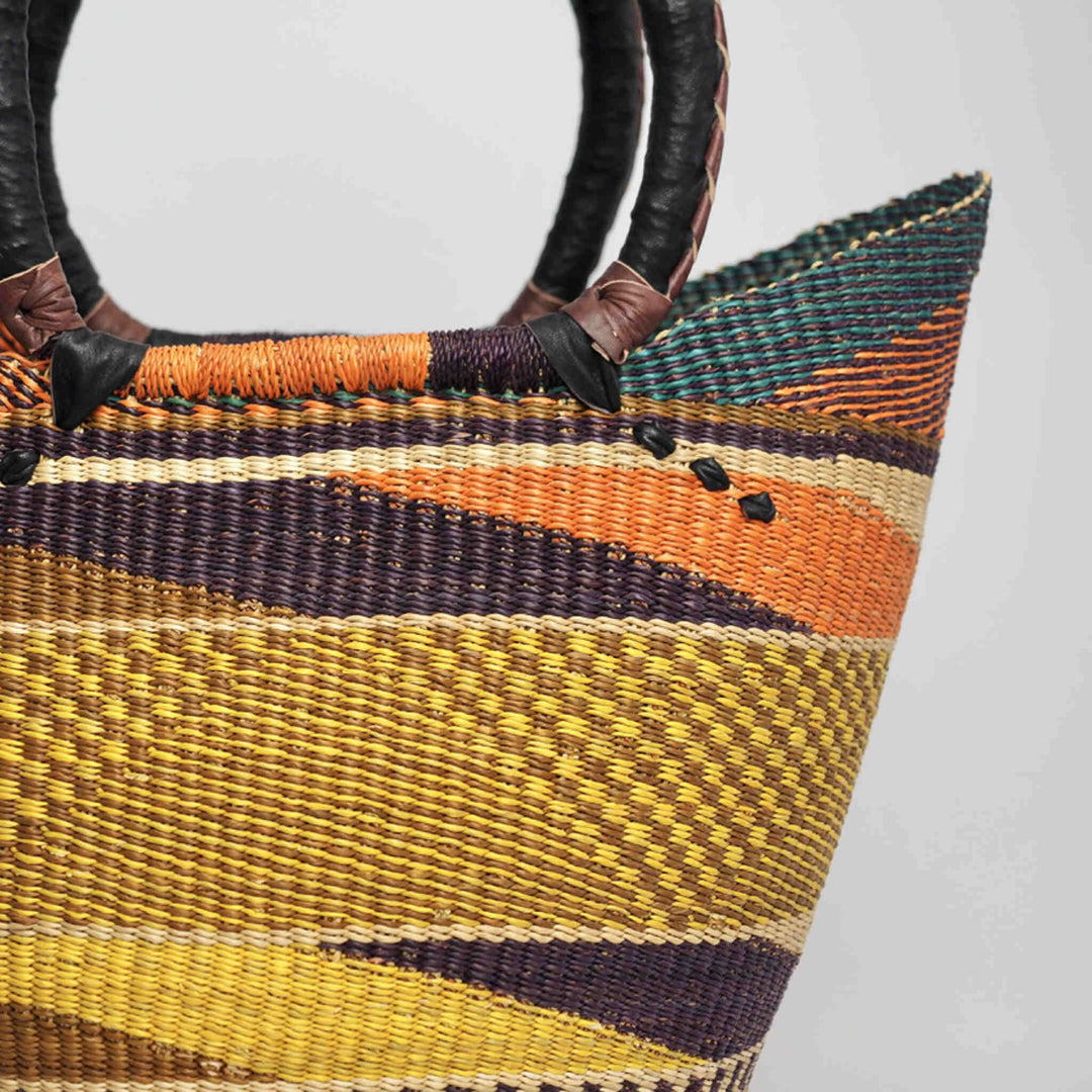 Close up of U Shopper Basket large with leather handles, in yellow orange and purple.