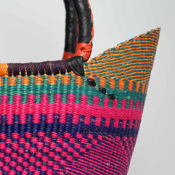 Close up of large shopper basket in vivid colours and leather handles