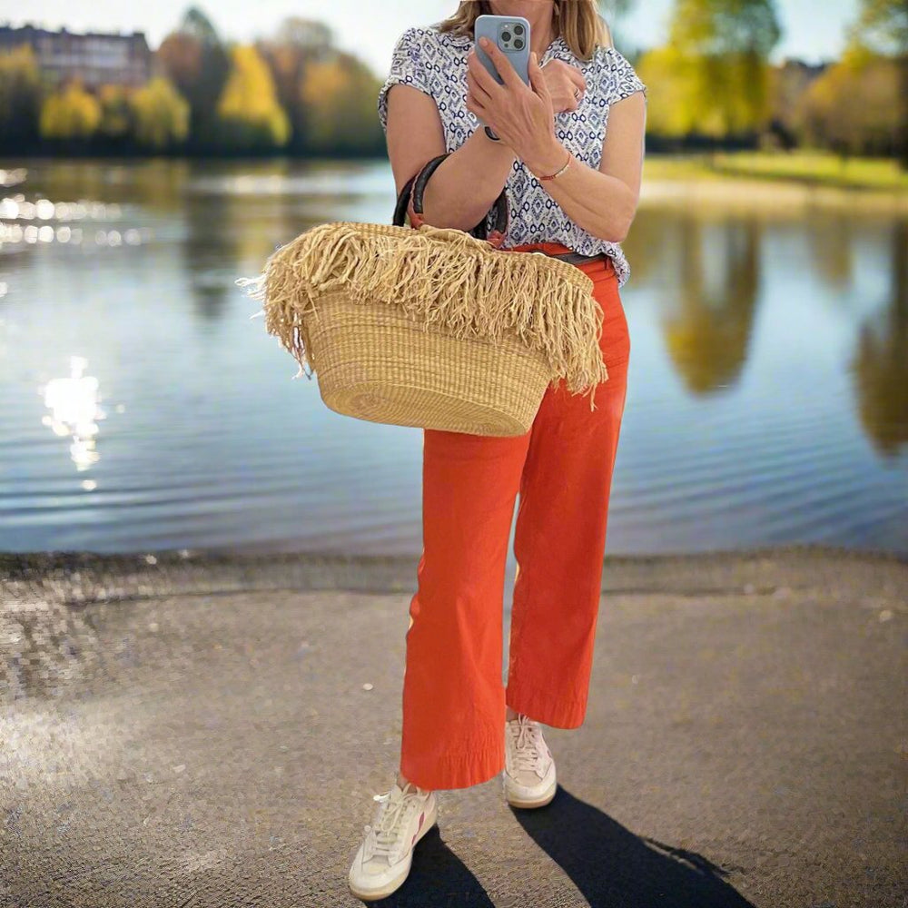 Basket with grass tassel trim by a pond