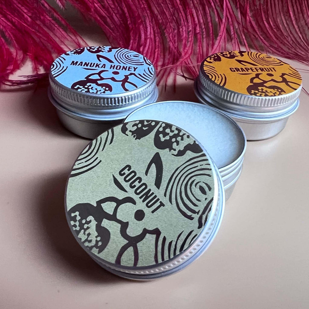 Trio of lip balm tins with a close up of Coconut, with lid off
