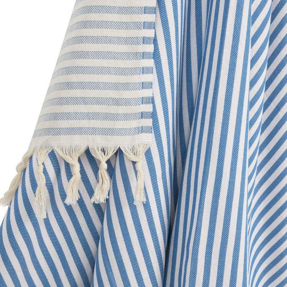 Close up of blue and white striped travel and beach blanket with hand tied tassels.