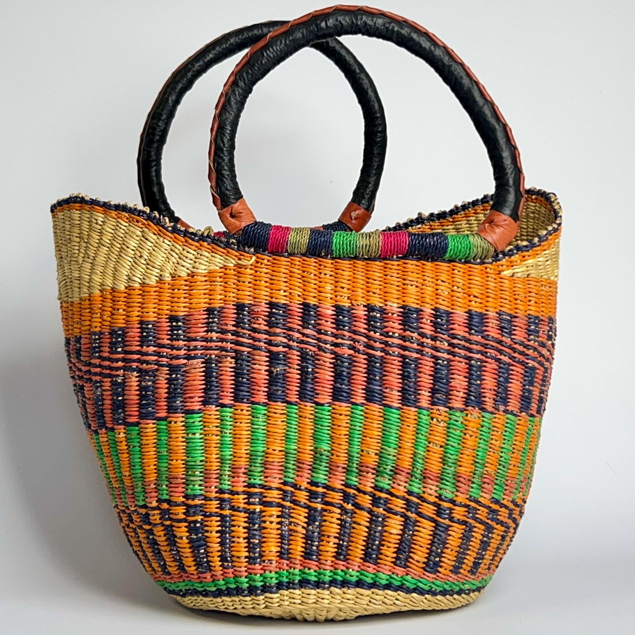 Bright orange, blue and lime shopper basket from Ghana, with black leather handles and a decorative and colourful design.
