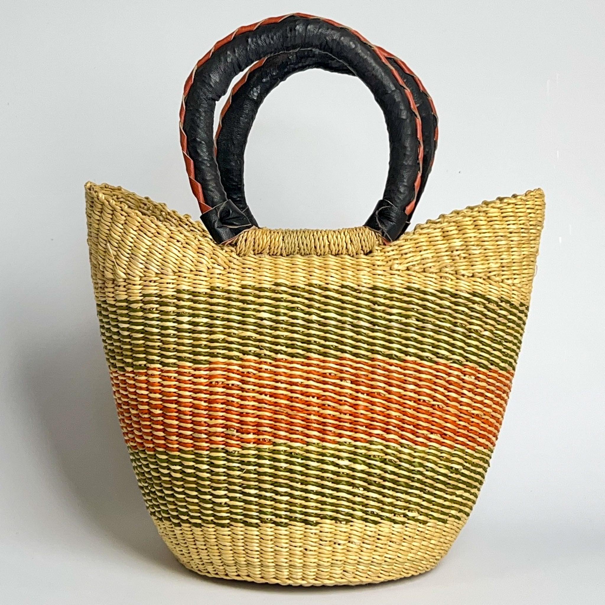 Traditional mini Ghanian shopper basket with black and tan leather handles, with natural tones and green and burnt orange striped pattern.