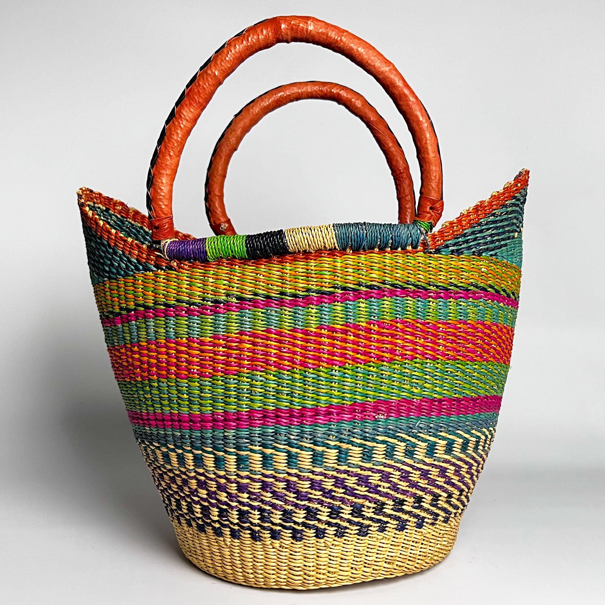 Colourful U Shape traditional Ghanian shopper basket in greens and red design and with tan and black leather handles.