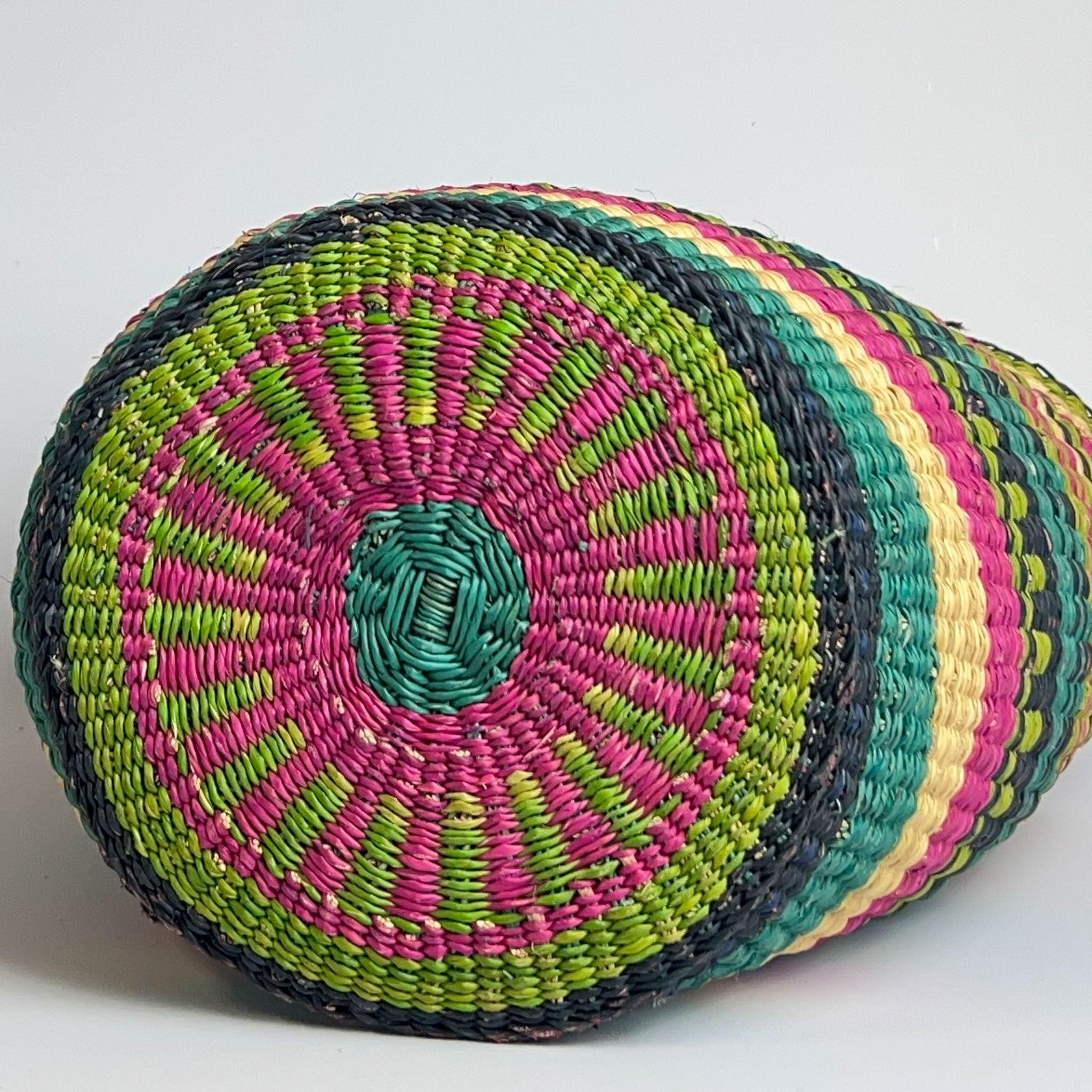 The base view of a traditional African Shopper basket showing off the pretty and colourful design in green and pink.