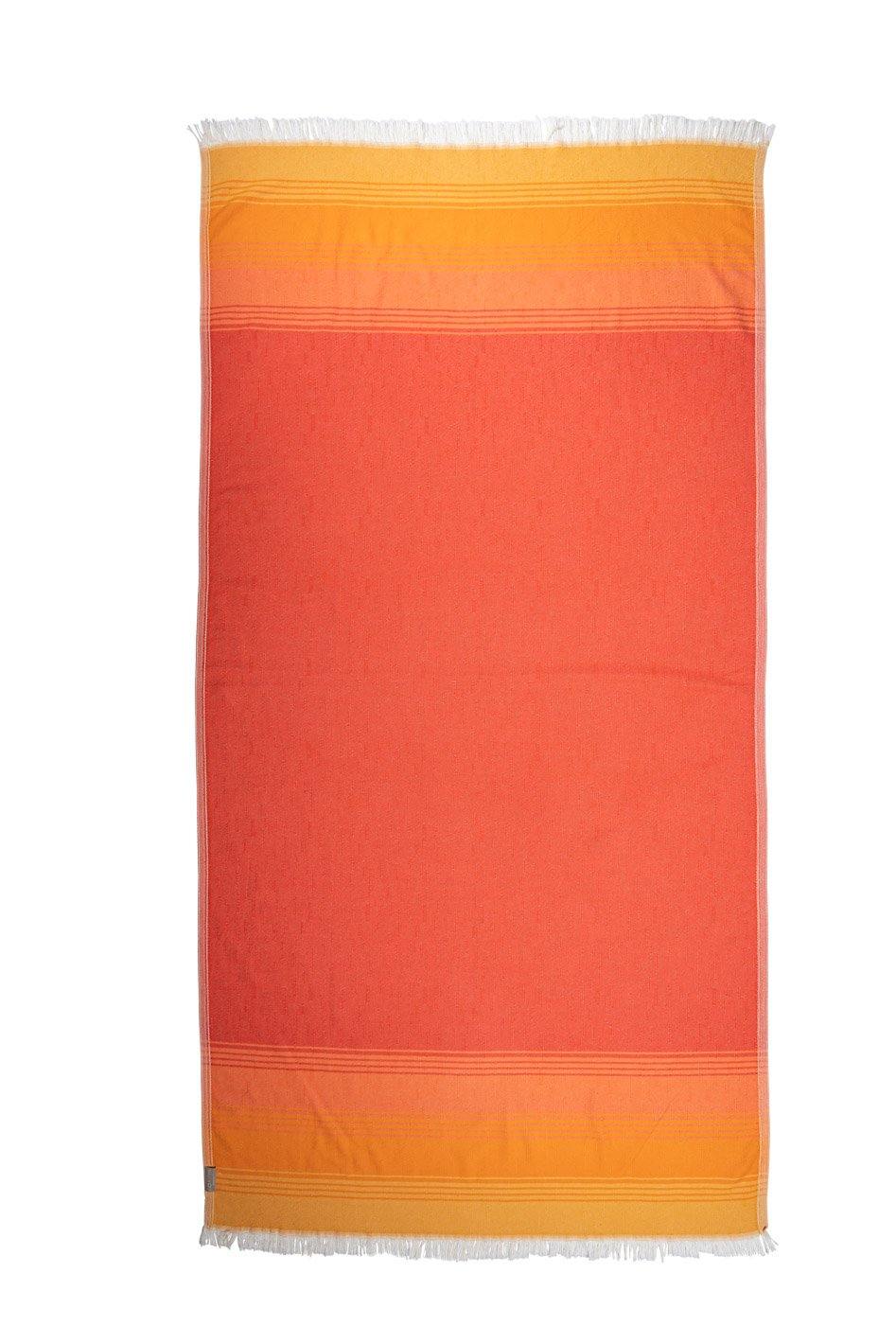 Sunset inspired colours make up this lightweight beach towel, taken against a white backdrop.