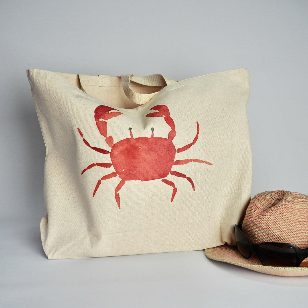 XL Canvas Tote Bag with a fun crab design print on front in coral, accessorised with sunhat and sunglasses ready for a day at the beach.  