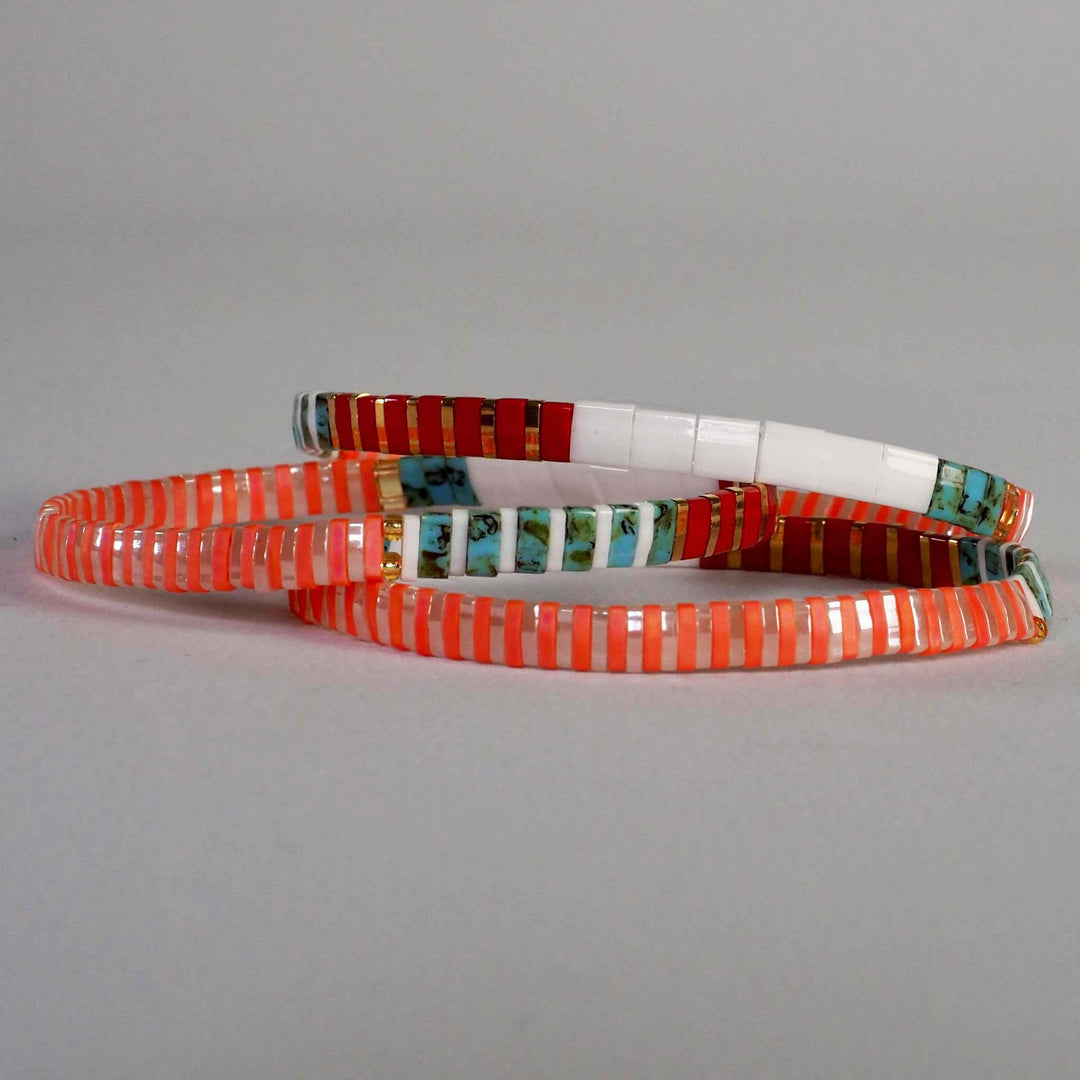 Three colourful Miyuki Glass Bead bracelets stacked on top of each other and in a standout coral, red, turquoise and white design.  